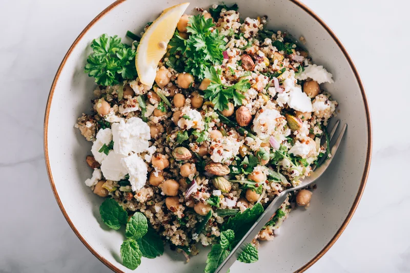 Healthy quinoa and chickpea salad with feta, pistachios, and fresh herbs for plant protein.