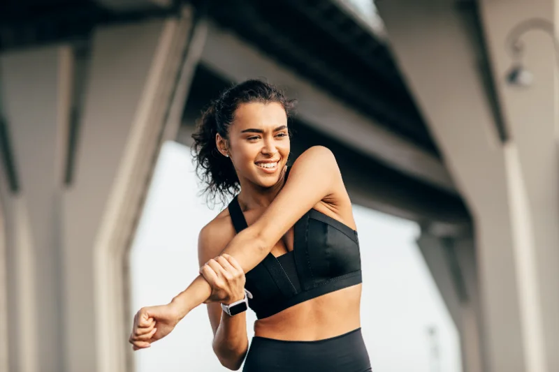 Woman in sportswear stretching outdoors before workout as part of quick wedding fitness plan.