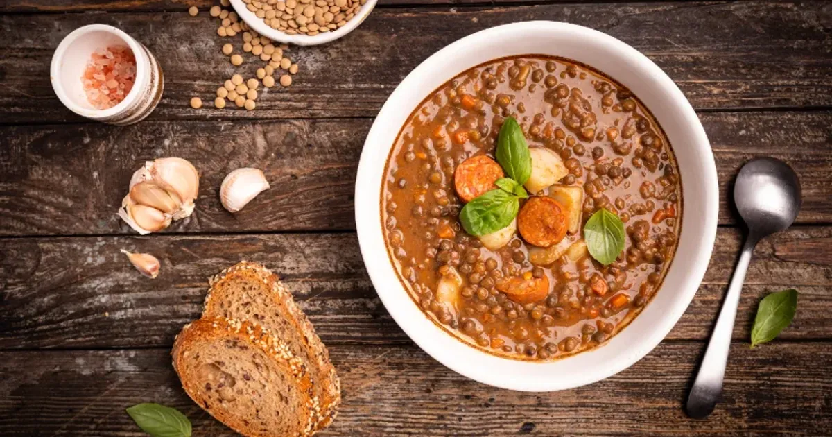 Traditional bowl of lentil stew with bread and vegetables, packed with protein for muscle growth.