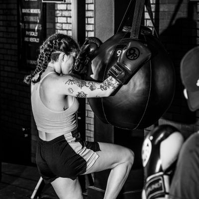 Beginner learning kickboxing combinations with a trainer at 9Round Lakeview on Broadway in Chicago’s Lakeview neighborhood