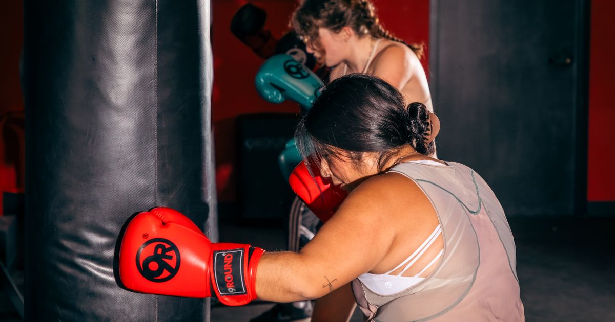 Member hitting heavy bag during a walk-in kickboxing session at 9Round Wicker Park on Division Street