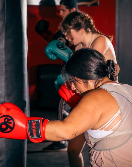 Member hitting heavy bag during a walk-in kickboxing session at 9Round Wicker Park on Division Street