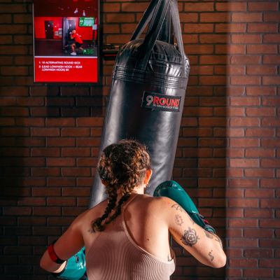 Member training on heavy bag during HIIT kickboxing session at 9Round Lakeview on Broadway in Chicago