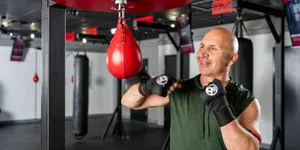 Man training on a red speed bag during a 9Round HIIT workout session