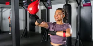 Woman training on a red speed bag during a 9Round HIIT workout session