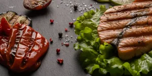 Grilled salmon steak served with lettuce, lime slices, and roasted vegetables for a healthy pre-wedding meal