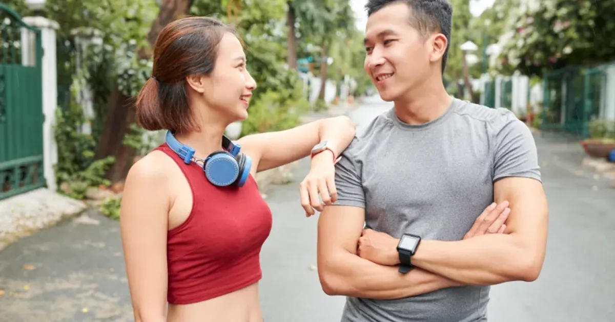 Sporty man and woman smiling together after workout, building fitness for their wedding day
