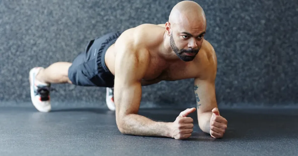 Focused man holding a plank exercise for core strength during a HIIT workout