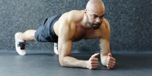 Focused man holding a plank exercise for core strength during a HIIT workout