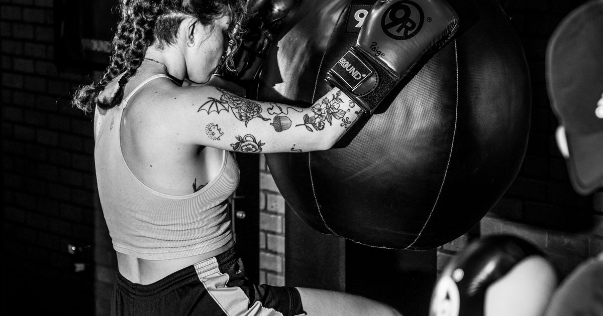 Member throwing a punch on a heavy bag during a 30-minute kickboxing circuit at 9Round Wicker Park in Chicago