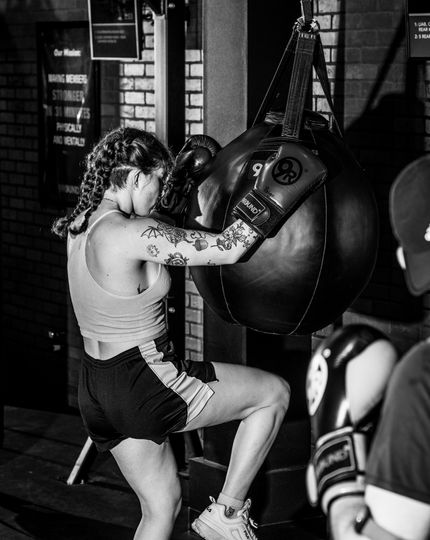 Member throwing a punch on a heavy bag during a 30-minute kickboxing circuit at 9Round Wicker Park in Chicago