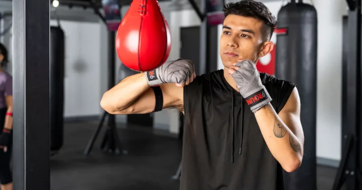 Beginner practicing proper punching form during a 9Round HIIT workout