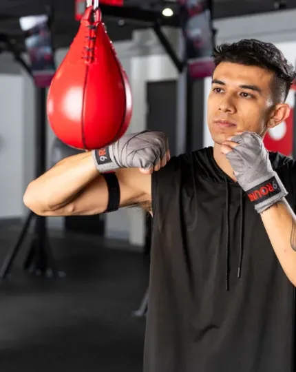Beginner practicing proper punching form during a 9Round HIIT workout
