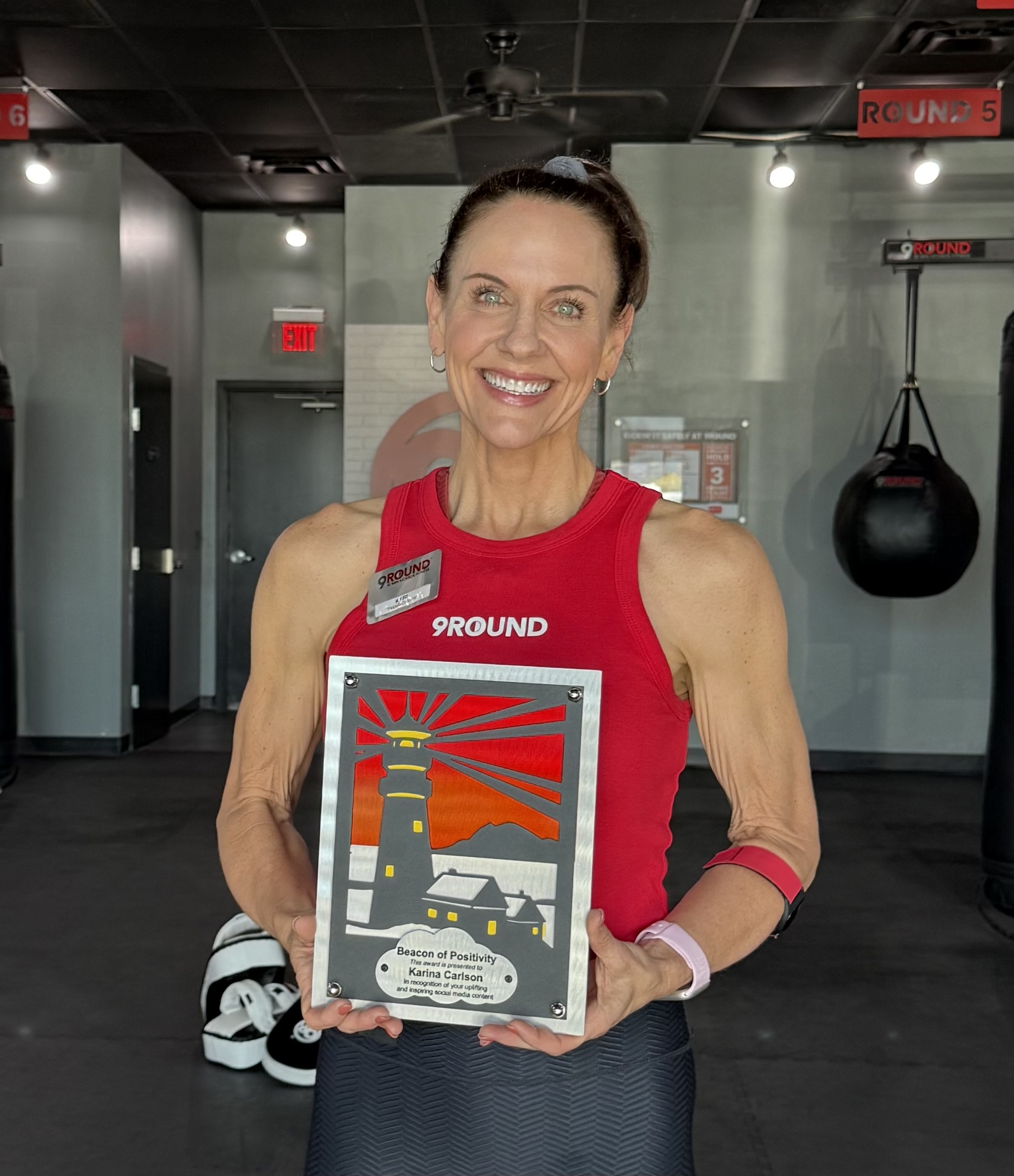 9Round owner posing with a local award” 
     style=