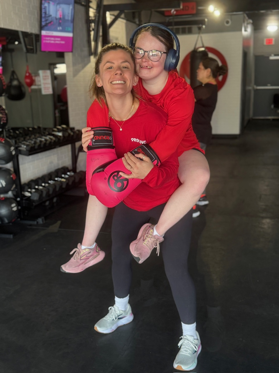 9Round owner posing with member at her studio” 
     style=