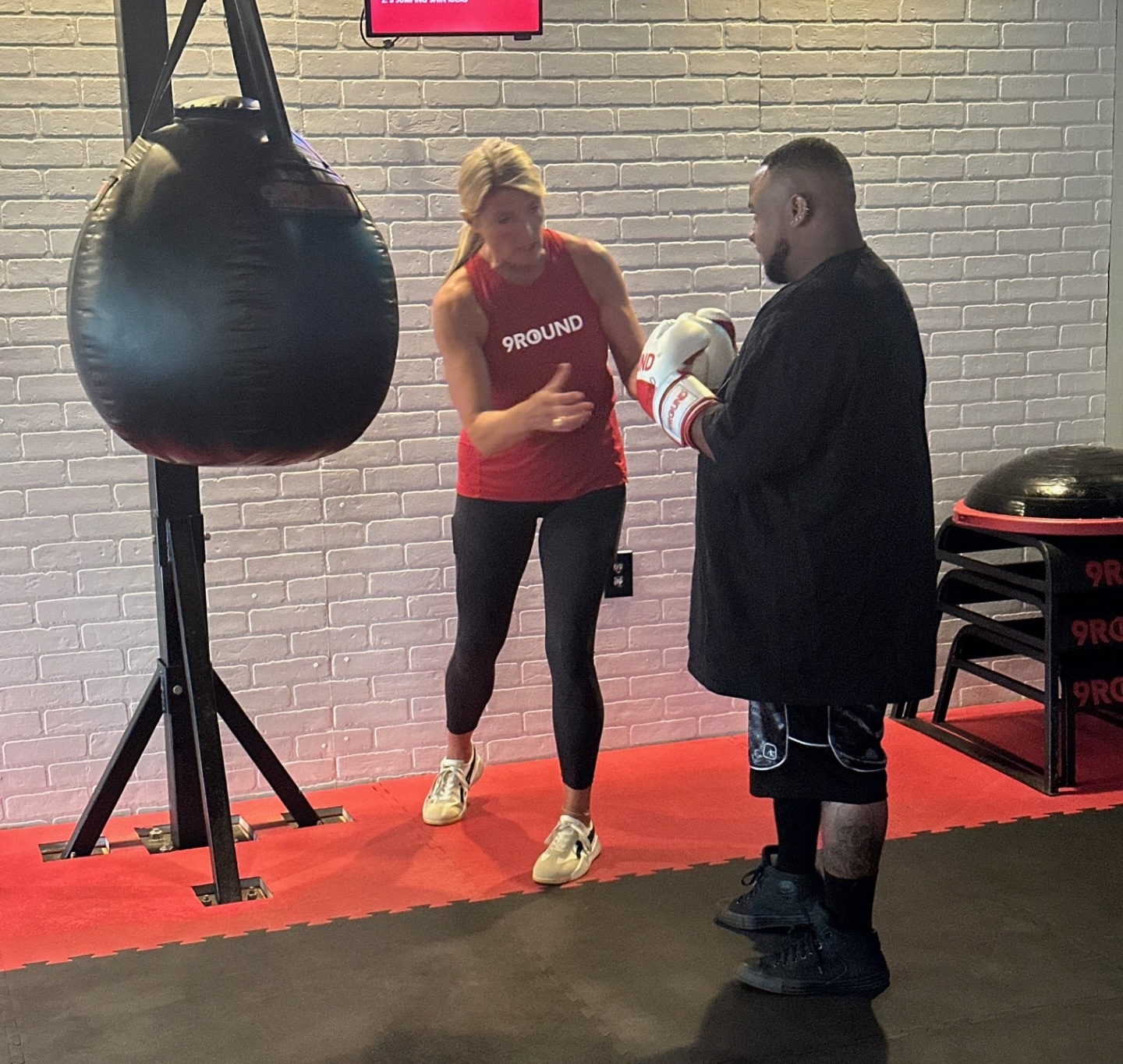 9Round owner working one on one with a member” 
     style=
