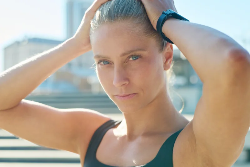 Close-up of a fit woman wearing a smartwatch and looking focused before workout.