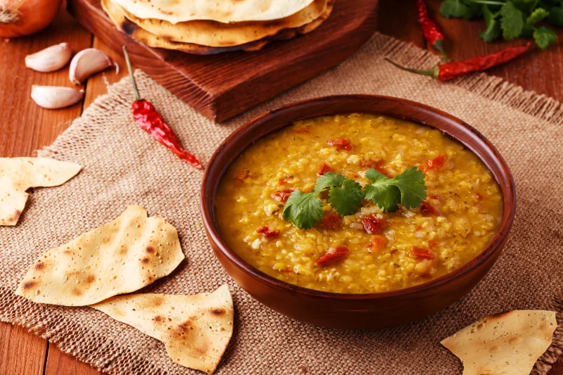 Indian Red Lentil Soup (Dal) for Plant Protein Traditional Indian red lentil soup (dal) with herbs and spices, a protein-rich plant-based meal.