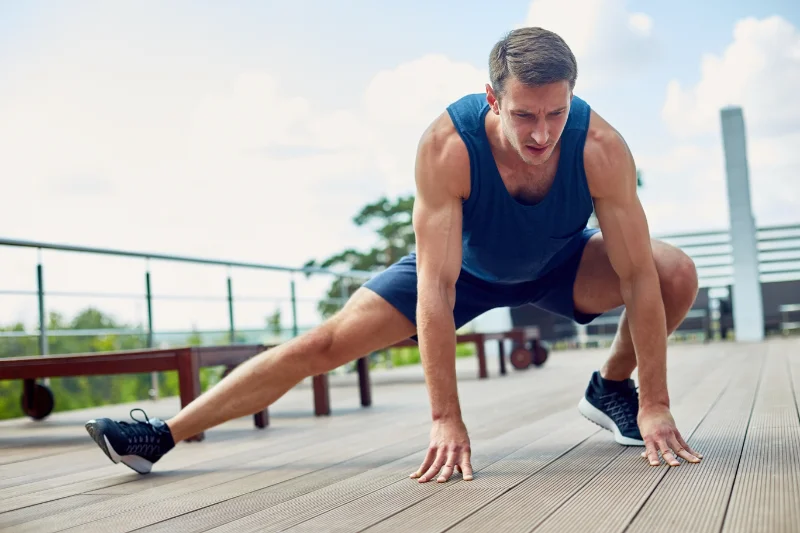 Athlete stretching outdoors while preparing for marathon with 9RoundNOW bodyweight training